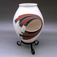 A polychrome jar with two cutouts and decorated with a two-panel geometric design
 by Roberto Olivas of Mata Ortiz and Casas Grandes