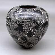 A black on white jar decorated with a sgraffito wildlife and mesh design
 by Alex Ortega of Mata Ortiz and Casas Grandes