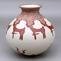 A red on white jar with a rolled lip and decorated with a sgraffito deer and geometric design
 by Leonel Lopez Sr of Mata Ortiz and Casas Grandes