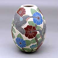 A polychrome jar decorated with a sgraffito and painted hummingbird, butterfly, flower, leaf and branch design
 by Karla Flores of Mata Ortiz and Casas Grandes