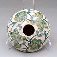 A polychrome seed pot decorated with a lightly carved, sgraffito and painted hummingbird, vine, flower and berry design
 by Melissa Tena of Mata Ortiz and Casas Grandes