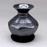 A black on black jar with an octagonal base, a rolled lip and decorated with a feather and lace geometric design
 by Susy Martinez of Mata Ortiz and Casas Grandes