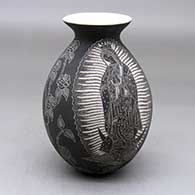 A black on white jar with a rolled lip and decorated with a Virgin of Guadalupe, rose, vine and geometric design
 by Hector Javier Martinez of Mata Ortiz and Casas Grandes