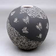 A black on white jar decorated with a sgraffito butterfly and geometric design
 by Hector Javier Martinez of Mata Ortiz and Casas Grandes