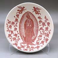 A shallow red on white bowl decorated on the inside with a sgraffito Virgin of Guadalupe, rose, vine, angel and geometric design
 by Hector Javier Martinez of Mata Ortiz and Casas Grandes