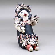 A sitting grandmother storyteller figure with fifteen children on her, click or tap to see a larger version