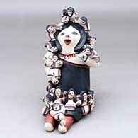 A sitting grandmother storyteller figure with fifteen children on her
 by Denise Eustace of Cochiti