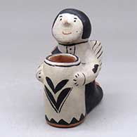 A kneeling angel figure holding a tall cylinder
 by Sarah Arquero of Cochiti