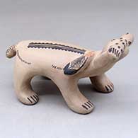 A polychrome bear figure with a fish in its mouth and decorated with a feather applique and geometric design
 by Snowflake Flower of Cochiti