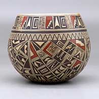 A polychrome bowl polished on the inside and decorated around the outside with a four panel small sherd and geometric design, click or tap to see a larger version