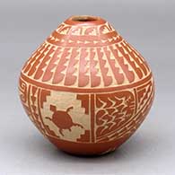 A red seed pot decorated with a sgraffito turtle, corn plant, feather, arrowhead and geometric design
 by Alvina Yepa of Jemez