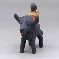 A polychrome figure with a little girl and her drum on the back of a bison
 by Felicia Fragua of Jemez