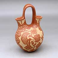 A red wedding vase decorated with a sgraffito hummingbird, butterfly, flower, leaf, branch and geometric design
 by Alvina Yepa of Jemez