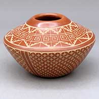 A red on buff jar decorated with a sgraffito snowflake, kiva step, spiral and geometric design
 by Wilma Baca Tosa of Jemez