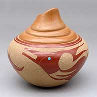 A red and tan jar with an organic opening, four shoulders and a sgraffito avanyu and geometric design with an inlaid stone
 by Brenda Tafoya of Jemez