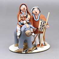 A polychrome Flight to Egypt piece on a platform
 by Mary Lucero of Jemez