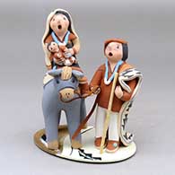 A polychrome Flight to Egypt piece on a platform
 by Mary Lucero of Jemez