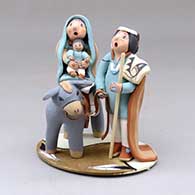 A polychrome Flight to Egypt piece on a platform
 by Mary Lucero of Jemez