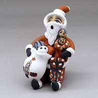 A sitting Santa Claus storyteller figure with two children and gifts
 by Felicia Fragua of Jemez