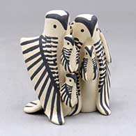 A black on tan standing owl couple with three chicks
 by Loren Wallowing Bull of Jemez