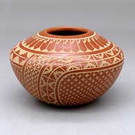 A red on buff jar decorated with a sgraffito snowflake, kiva step, feather and geometric design
 by Wilma Baca Tosa of Jemez
