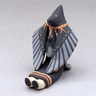 A sitting raven storyteller with one chick
 by Loren Wallowing Bull of Jemez