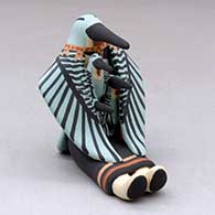 A sitting hummingbird storyteller with three chicks
 by Loren Wallowing Bull of Jemez