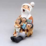 A sitting Santa Claus storyteller figure with four children, a kitten and gifts
 by Diane Lucero of Jemez