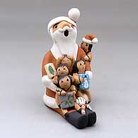 A sitting Santa Claus storyteller figure with five children and gifts
 by Diane Lucero of Jemez