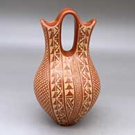 A red wedding vase decorated with a sgraffito snowflake, scroll, kiva step, feather and geometric design
 by Wilma Baca Tosa of Jemez