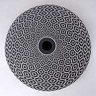 A black on white seed pot decorated with a swirling geometric design
 by Robert Kasero Sr of Laguna