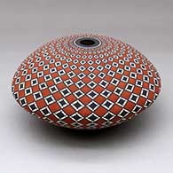 A polychrome seed pot decorated with a stylized spiral checkerboard geometric design
 by Robert Kasero Sr of Laguna