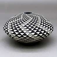 A black on white seed pot decorated with a spiral mesa geometric design
 by Robert Kasero Sr of Laguna