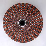 A polychrome seed pot decorated with a spiral checkerboard geometric design
 by Robert Kasero Sr of Laguna