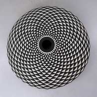 A black on white seed pot decorated with a spiral mesa geometric design
 by Robert Kasero Sr of Laguna