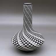 A black on white tall necked vase decorated with a spiral mesa geometric design
 by Robert Kasero Sr of Laguna