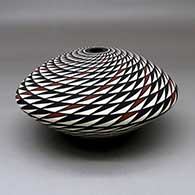 A polychrome seed pot decorated with a spiral mesa geometric design, click or tap to see a larger version