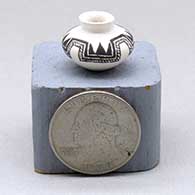 A miniature black on white jar decorated with a four panel fineline and geometric design
 by Thomas Natseway of Laguna