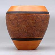 A black on red jar decorated around the body with a snowflake fineline geometric design, click or tap to see a larger version