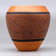 A black on red jar decorated around the body with a snowflake fineline geometric design, click or tap to see a larger version