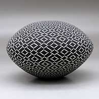 A black on white seed pot decorated with a spiraling geometric design, click or tap to see a larger version