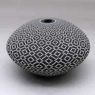 A black on white seed pot decorated with a spiraling geometric design
 by Robert Kasero Sr of Laguna