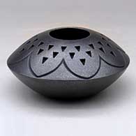 A black micaceous jar decorated with a lightly carved geometric design and a corrugated geometric design above the shoulder
 by Robert Vigil of Nambe