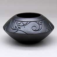 A micaceous black bowl with an avanyu design lightly carved above the shoulder
 by Robert Vigil of Nambe