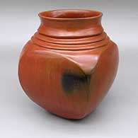 Red quadruple-shouldered jar with a square body, slightly flared opening, a pine pitch coating, and fire clouds
 by Samuel Manymules of Dineh