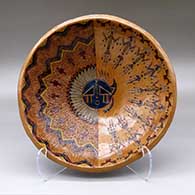 A wide polychrome bowl decorated inside with a sgraffito and painted Yeibichai, sun, feather, star and geometric design, and decorated outside with a geometric design
 by Nancy Yazzie of Dineh