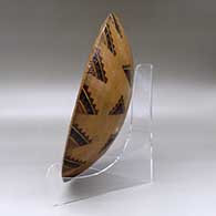 A wide, open polychrome bowl decorated inside with a sgraffito and painted Yeibichai, sun, feather, star and geometric design, and decorated outside with a geometric design, click or tap to see a larger version