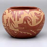 A red bowl with a sgraffito avanyu, butterfly, hummingbird and geometric design
 by Candelaria Suazo of Santa Clara