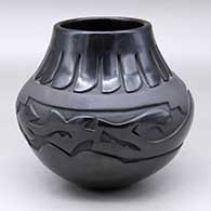 A black jar carved with an avanyu and feather design separated by a band of matte black geometric design
 by Sharon Naranjo Garcia of Santa Clara