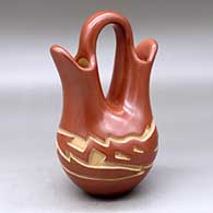 A red wedding vase carved with an avanyu design around the body
 by Vickie Martinez of Santa Clara